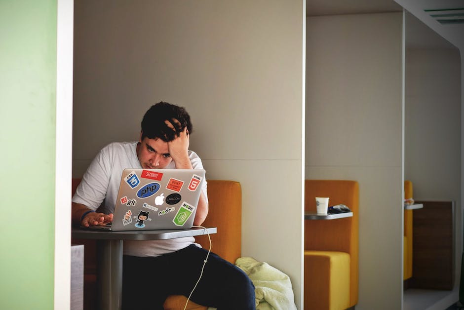 A person looking frustrated at a computer screen showing an error message.